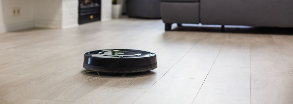 Robotic vacuum cleaner on laminate wood floor in living room