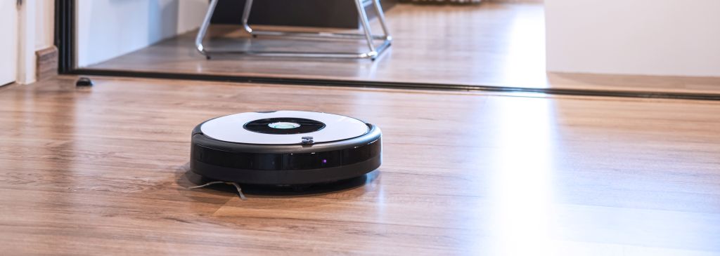 Robotic vacuum cleaner working on laminate wooden floor