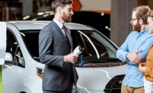 Sales manager selling electric car to a young couple