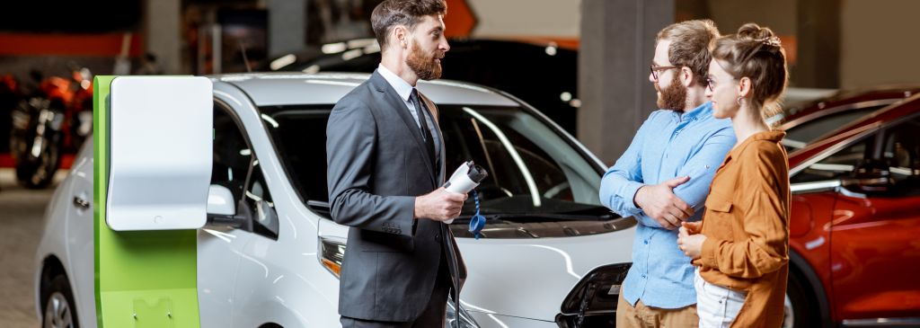 Sales manager selling electric car to a young couple