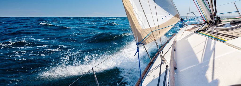 Sailing boat at open sea in sunshine